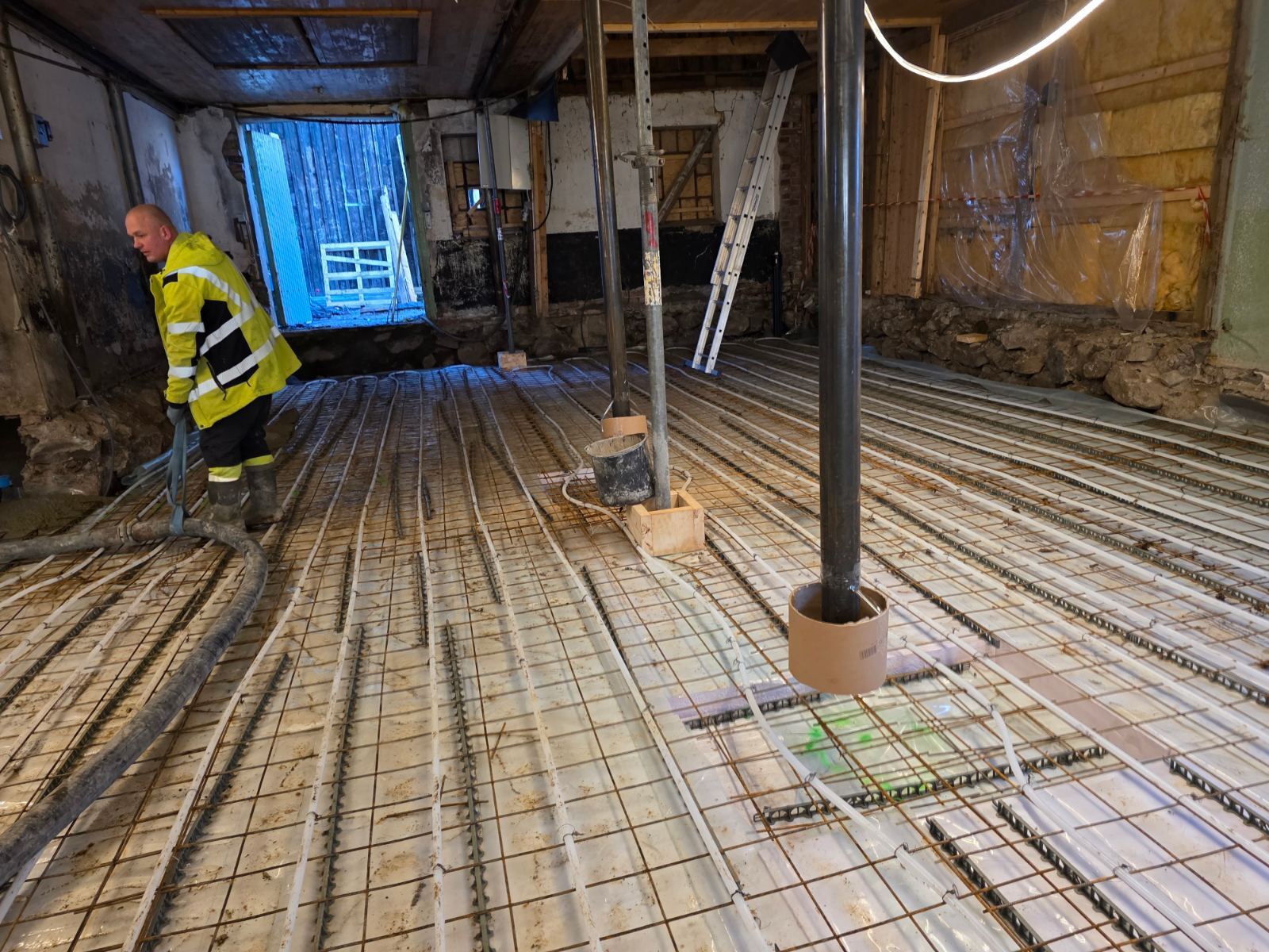 Nytt gulv med armering og varmerør under arbeid i låven